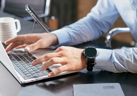 Berater arbeitet während eines Immobilien-Beratungsgesprächs am Laptop